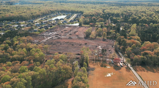 An aerial view of a construction site with trees in the background.